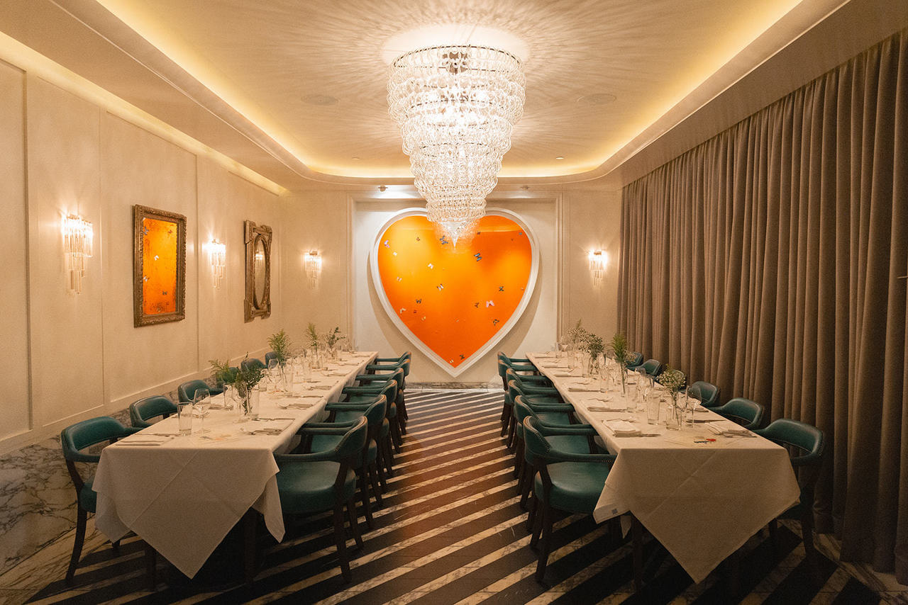 Two long dining tables with a giant painting of a heart